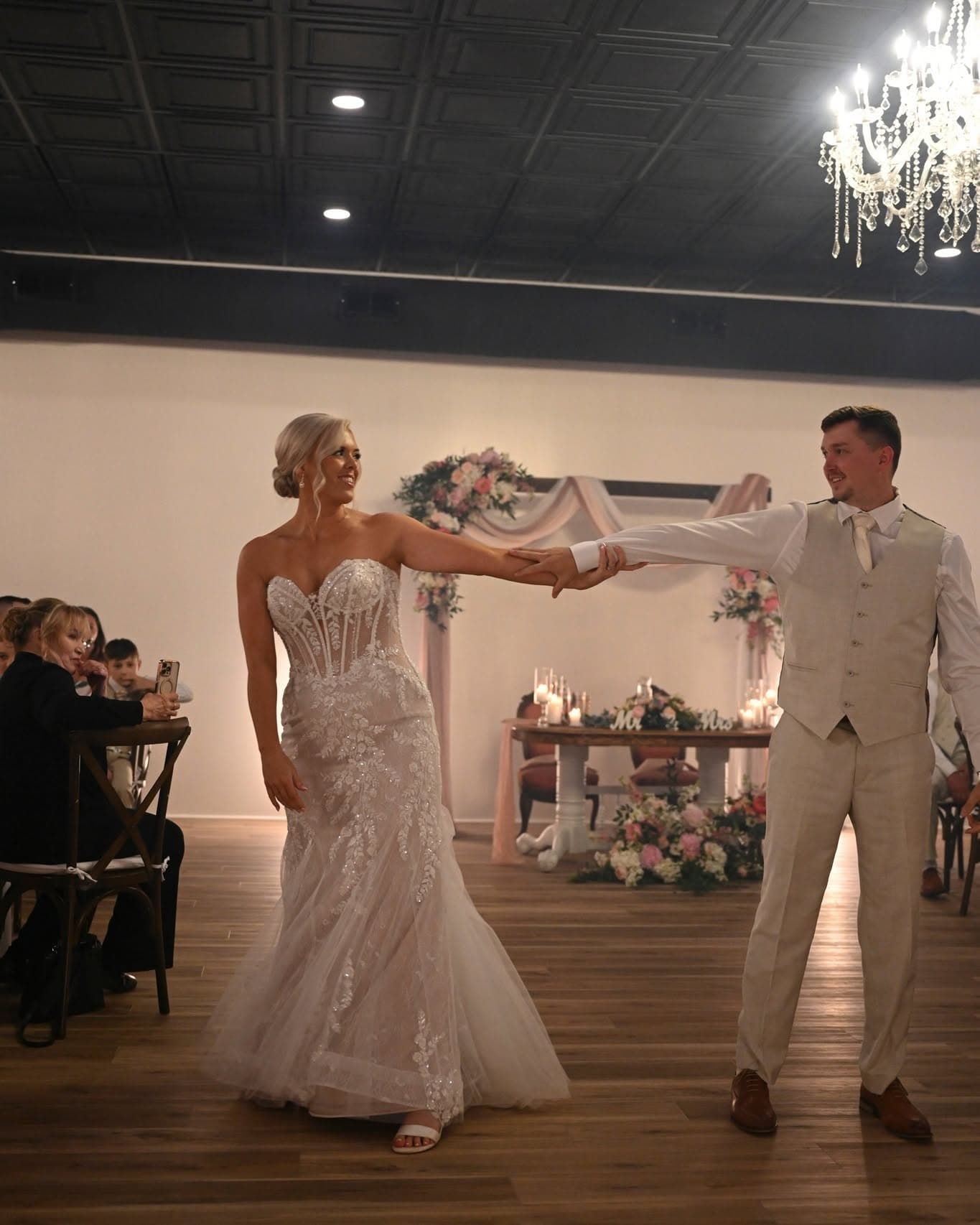 Bride and groom share their first dance under the chandelier at Becker Hill
