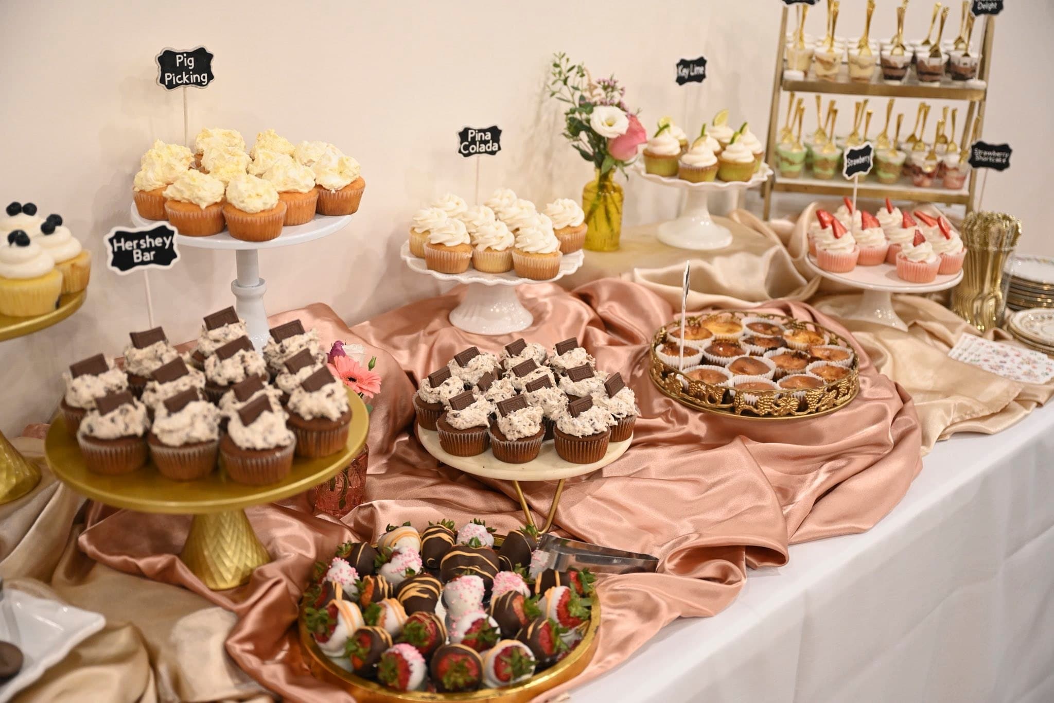 Assorted cupcake flavors and dessert cups displayed on a Becker Hill dessert table