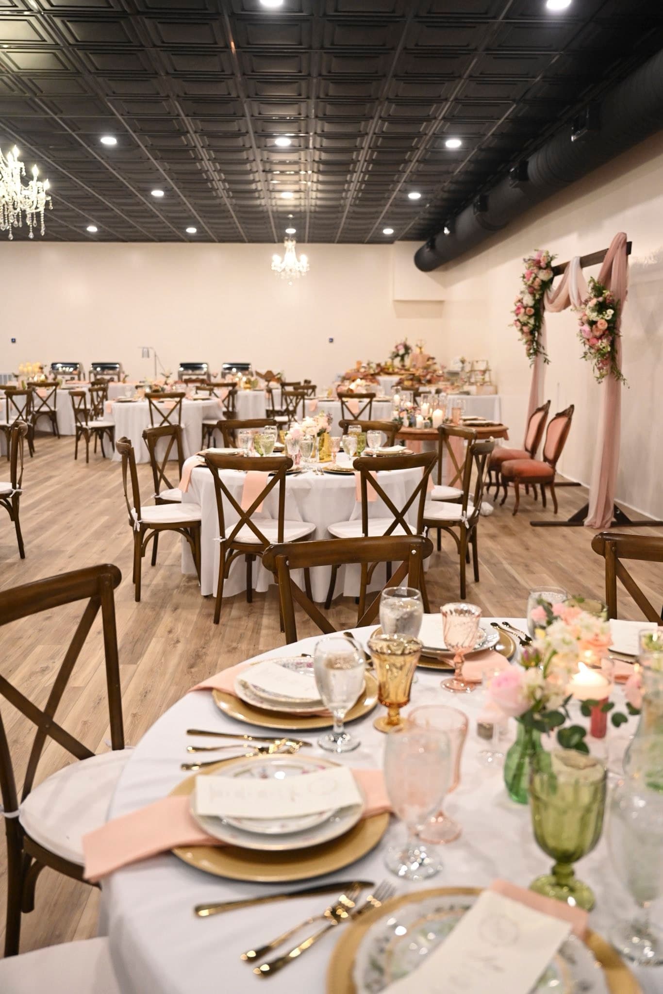 Wide view of the Becker Hill reception hall set for dinner with the ceremony arch backdrop