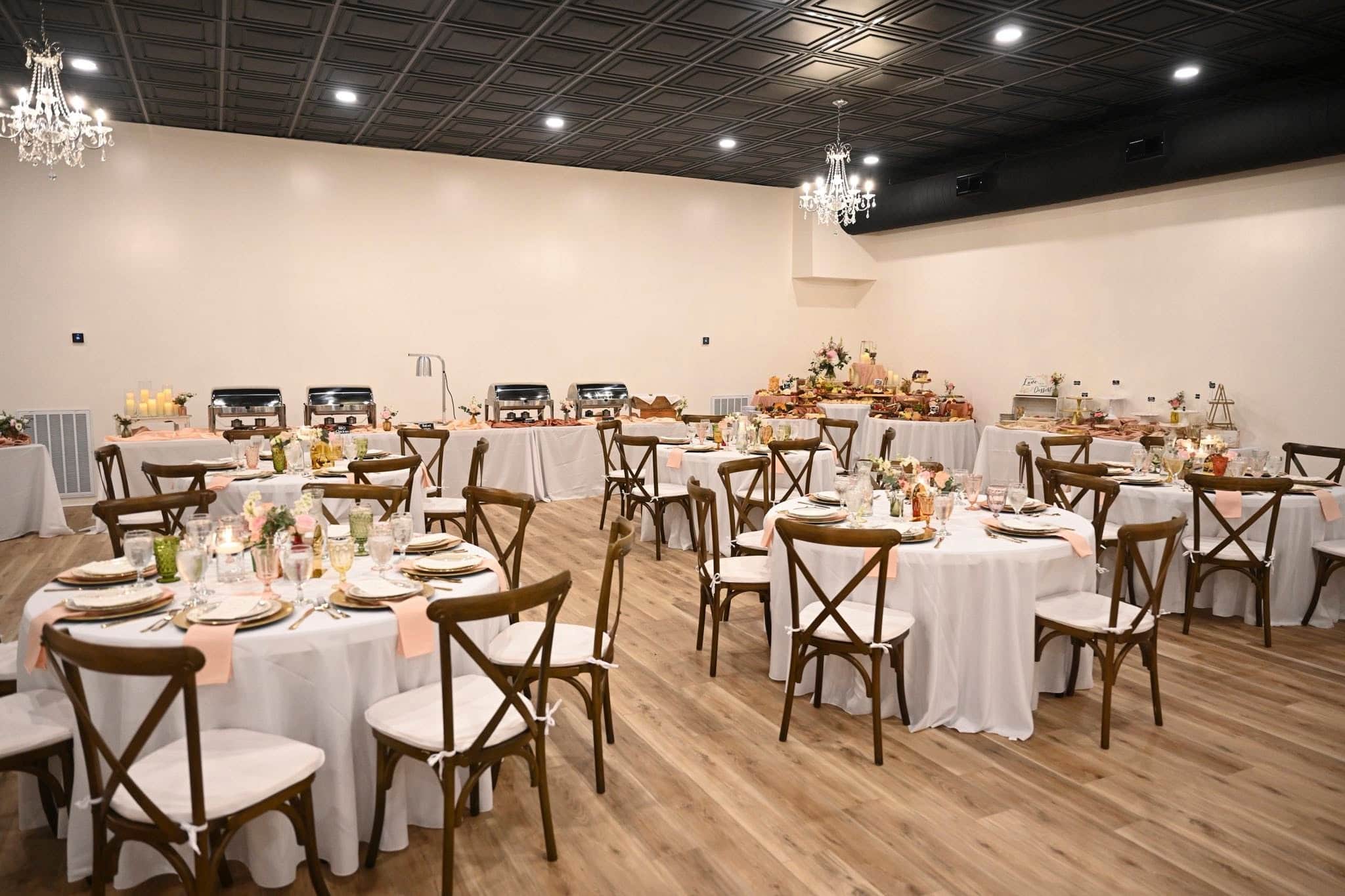 Elegant Becker Hill reception hall set with round tables, crystal chandeliers, and a buffet spread
