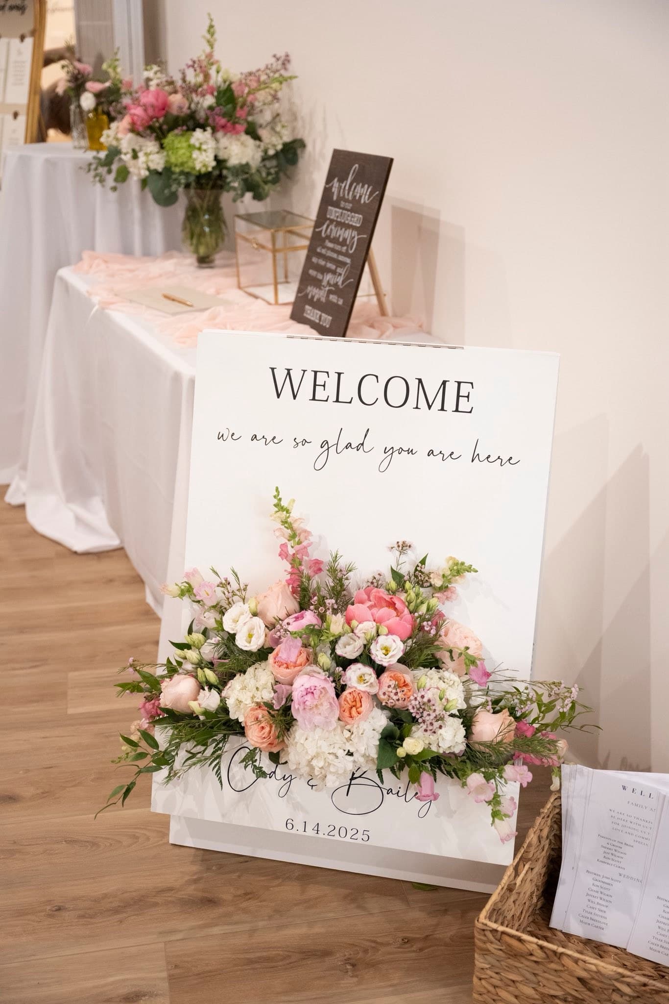 Welcome sign with fresh florals greeting guests at a Becker Hill wedding